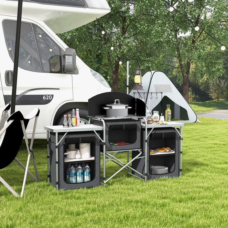 Outsunny Camping Kitchen Table, Portable Folding Camp Kitchen, Aluminum Cook Station with 3 Fabric Cupboards, Windshield, Carrying Bag, Black