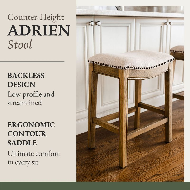 Maven Lane Adrien 26 Inch Counter Height Upholstered Backless Saddle Barstool in Natural Wood Finish with Wheat Cream Fabric Cushion Seat, Set of 3