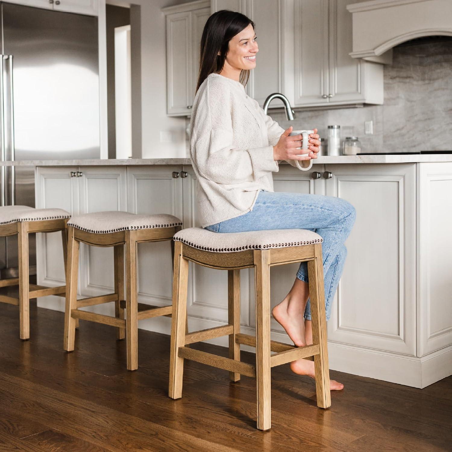 Maven Lane Adrien 26 Inch Counter Height Upholstered Backless Saddle Barstool in Natural Wood Finish with Wheat Cream Fabric Cushion Seat, Set of 3