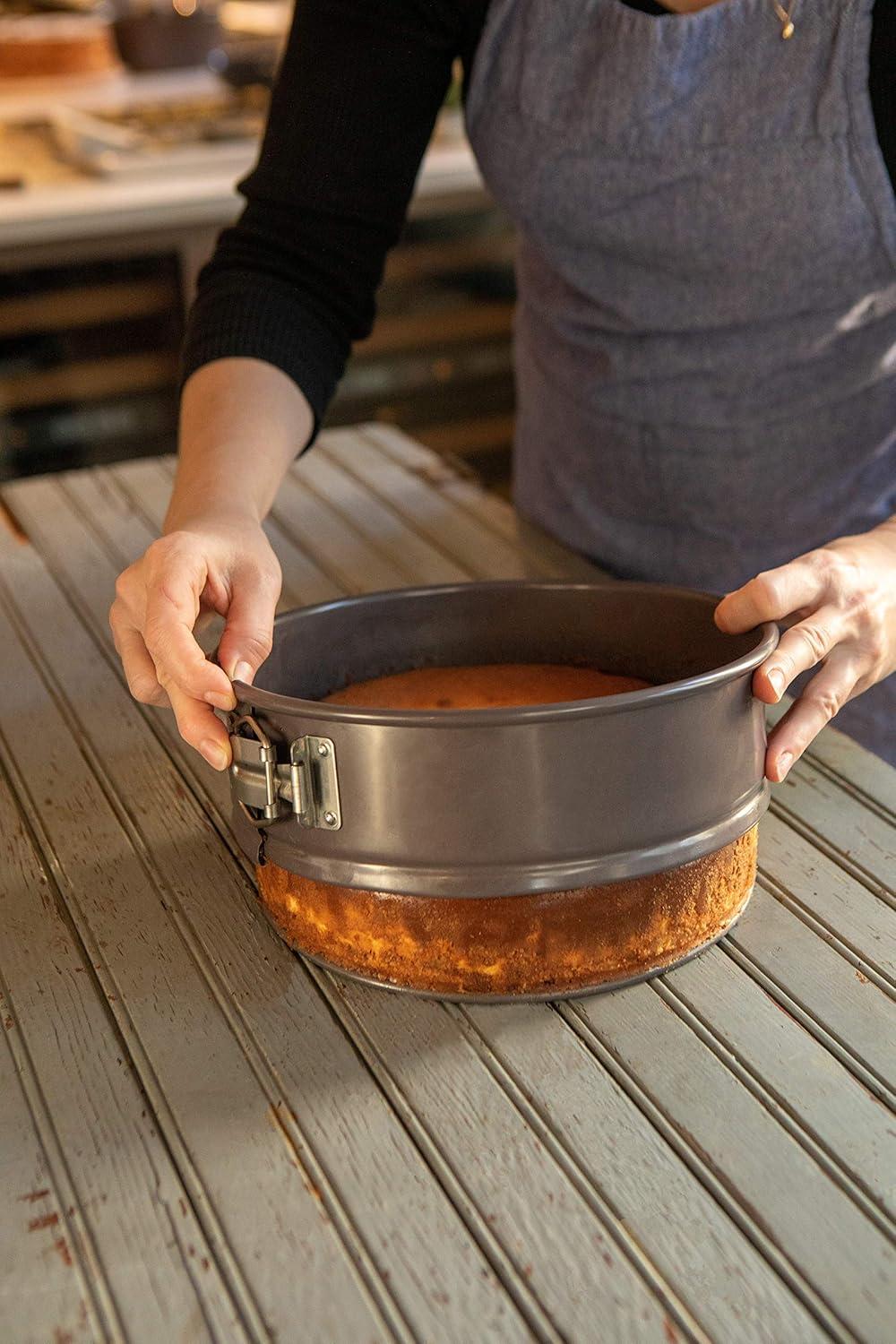 NutriChef 9 Inch Nonstick Cheesecake Springform Cake Pan | Stainless Steel Clasp & Removable Bottom | Durable Carbon Steel Cheesecake Pan | Easy to Clean | Includes 100 Parchment Papers | Black