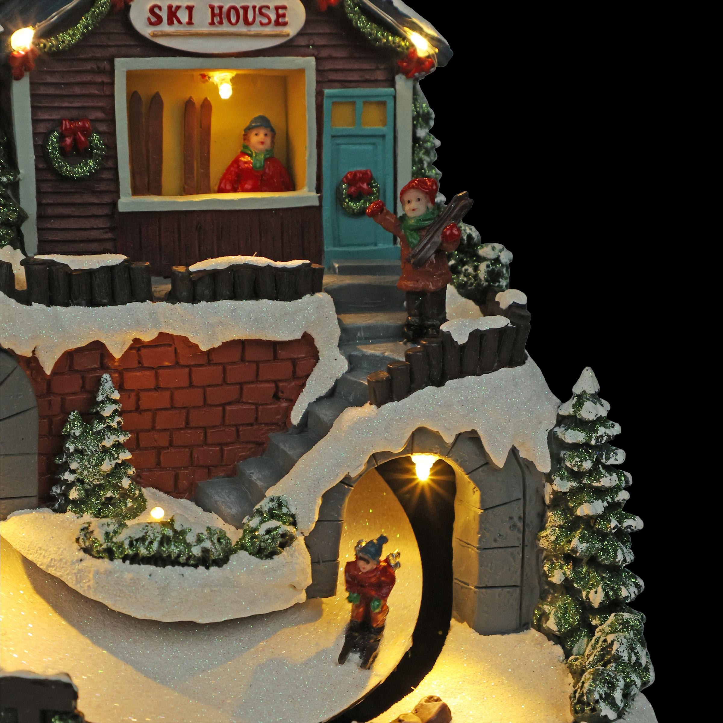 Alpine Corporation Animated Christmas Ski Resort Holiday Tabletop Decor with 12 Warm White LED Lights and Moving Skier Figurines, 12" L x 8" W x 9" H