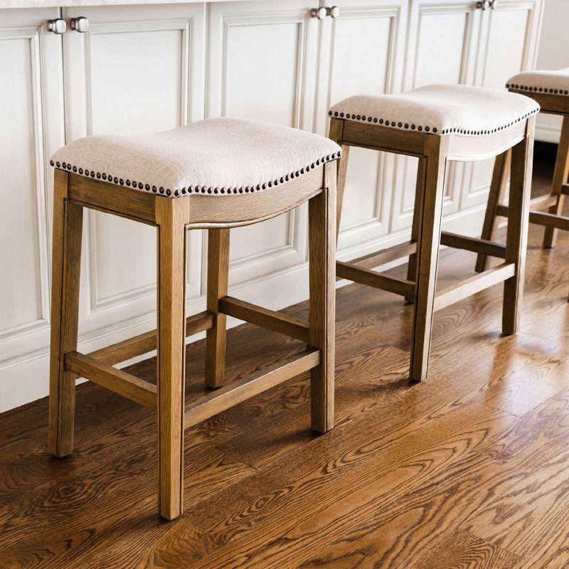 Maven Lane Adrien 31 Inch Bar Height Upholstered Backless Saddle Barstool in Natural Wood Finish with Wheat Cream Fabric Cushion Seat, Set of 2