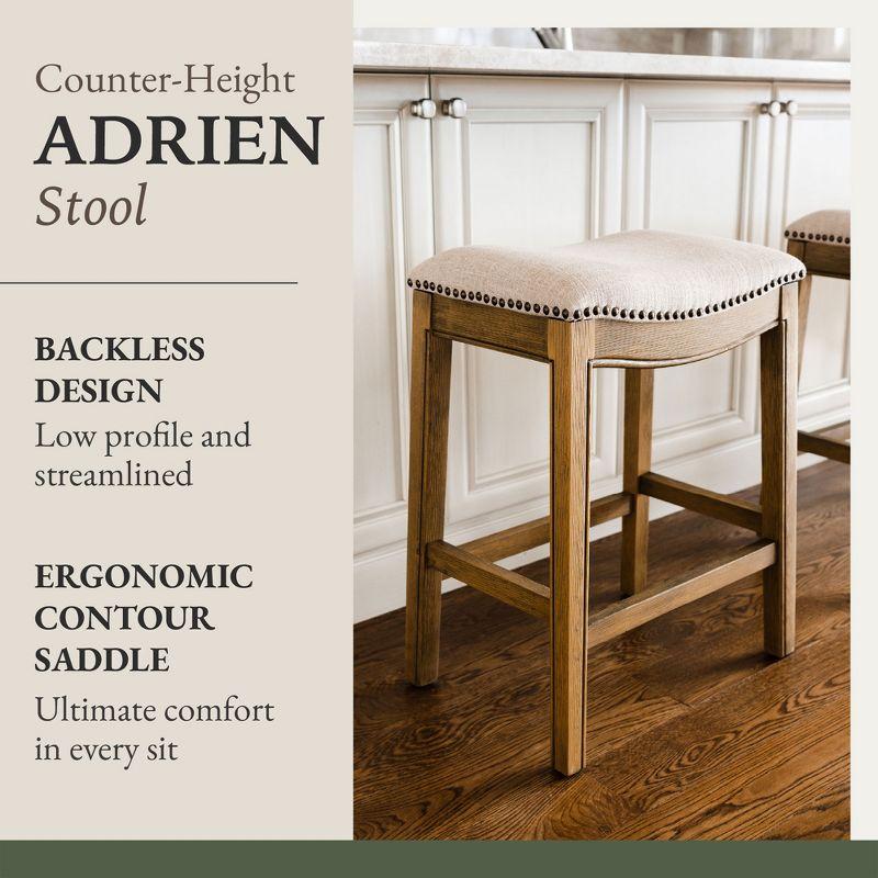 Maven Lane Adrien 26 Inch Counter Height Upholstered Backless Saddle Barstool in Natural Wood Finish with Wheat Cream Fabric Cushion Seat, Set of 3