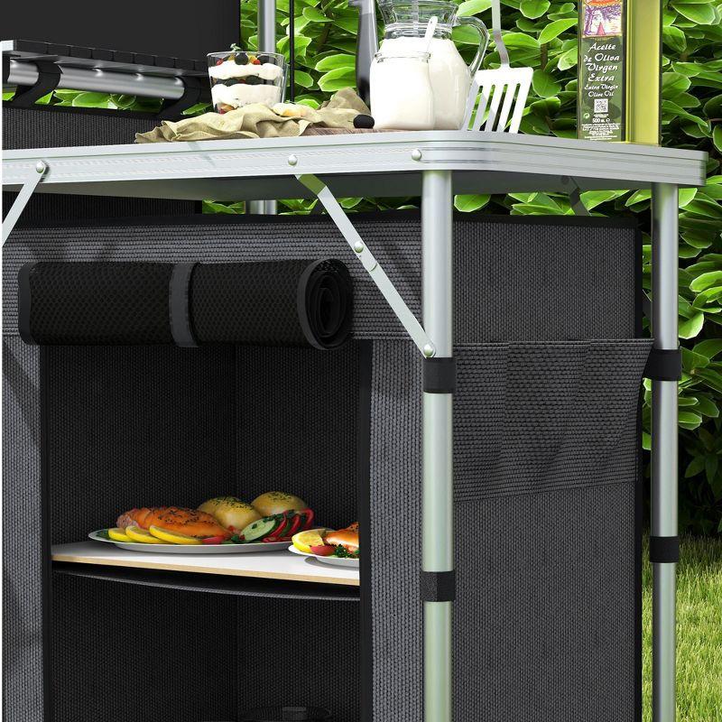 Outsunny Camping Kitchen Table, Portable Folding Camp Kitchen, Aluminum Cook Station with 3 Fabric Cupboards, Windshield, Carrying Bag, Black