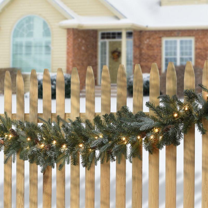 National Tree Company Pre-Lit 'Feel Real' Artificial Christmas Garland, Green, Arctic Spruce, White Lights, With Pine Cones, Plug In, 9 Feet